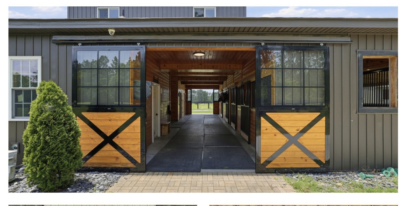 Open barn doors at 8520 Stock Horse Trail, looking down the center aisle toward the pasture.